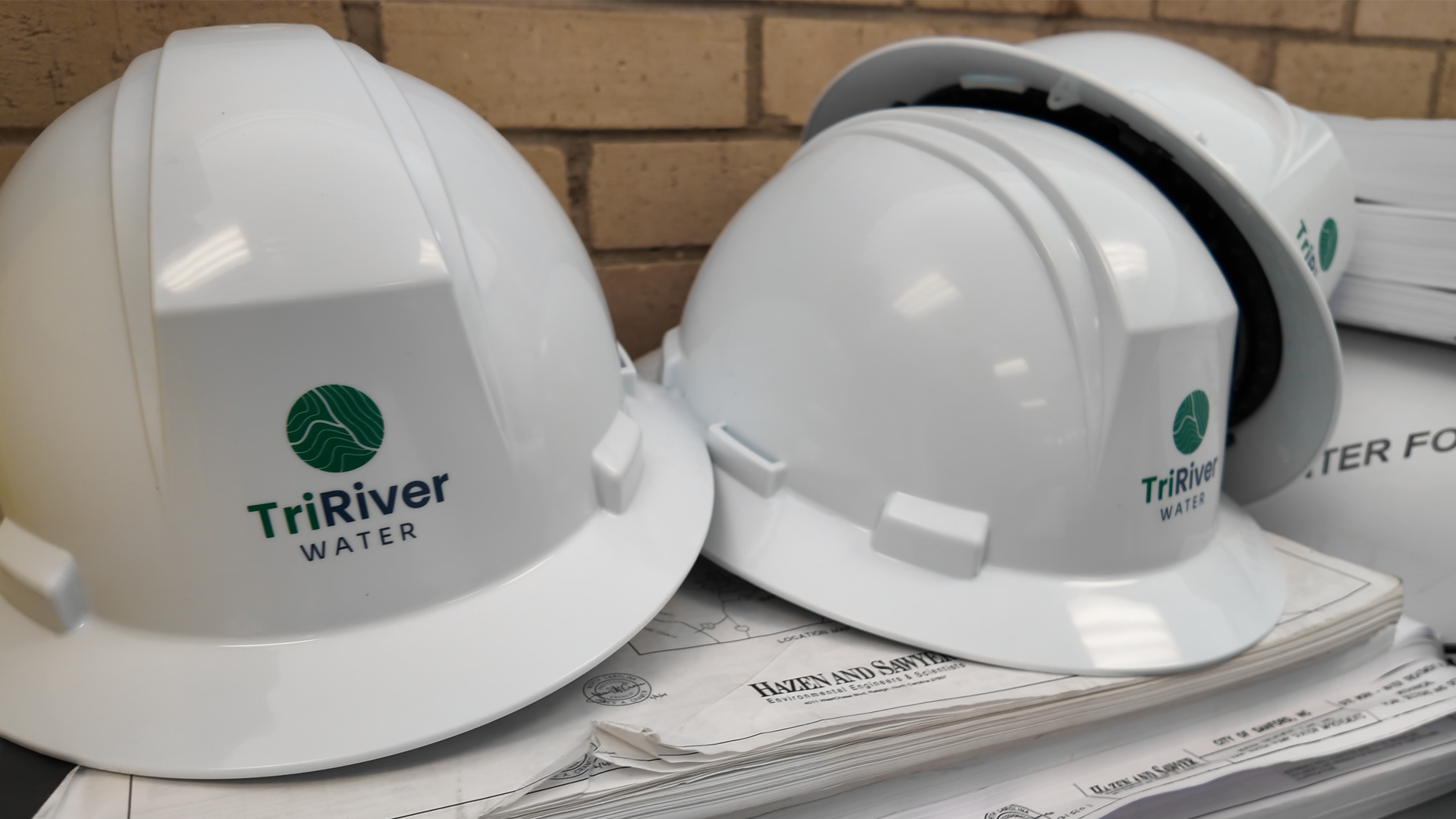 Hard hats featuring the TriRiver Water logo sitting on a shelf